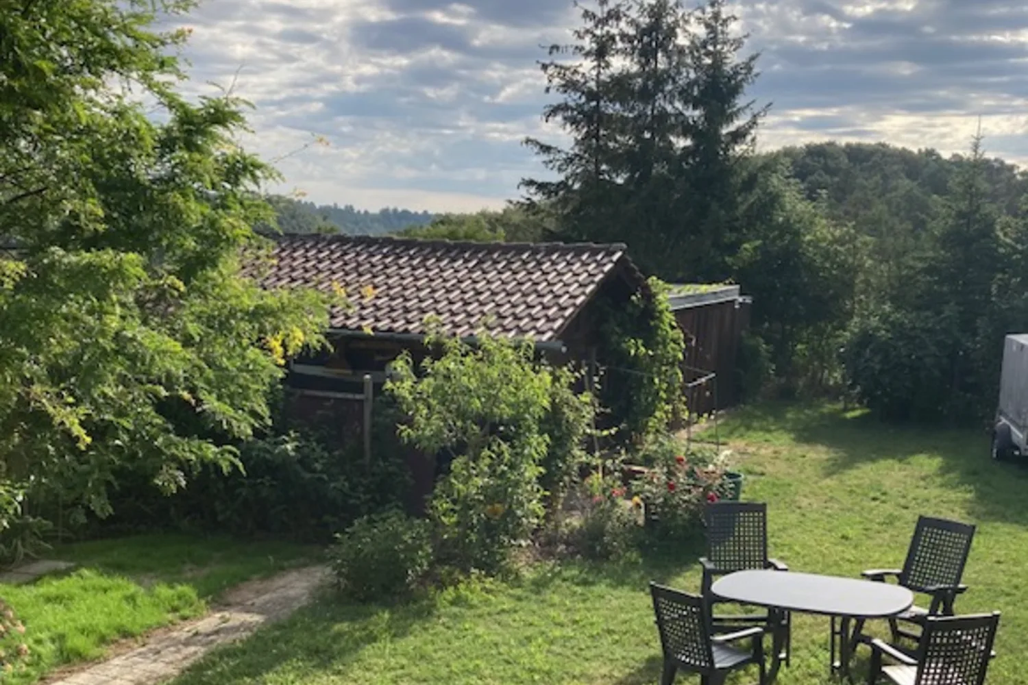 Großzügiger Garten der Casa Billa mit Tisch, Stühlen und Blick ins Grüne