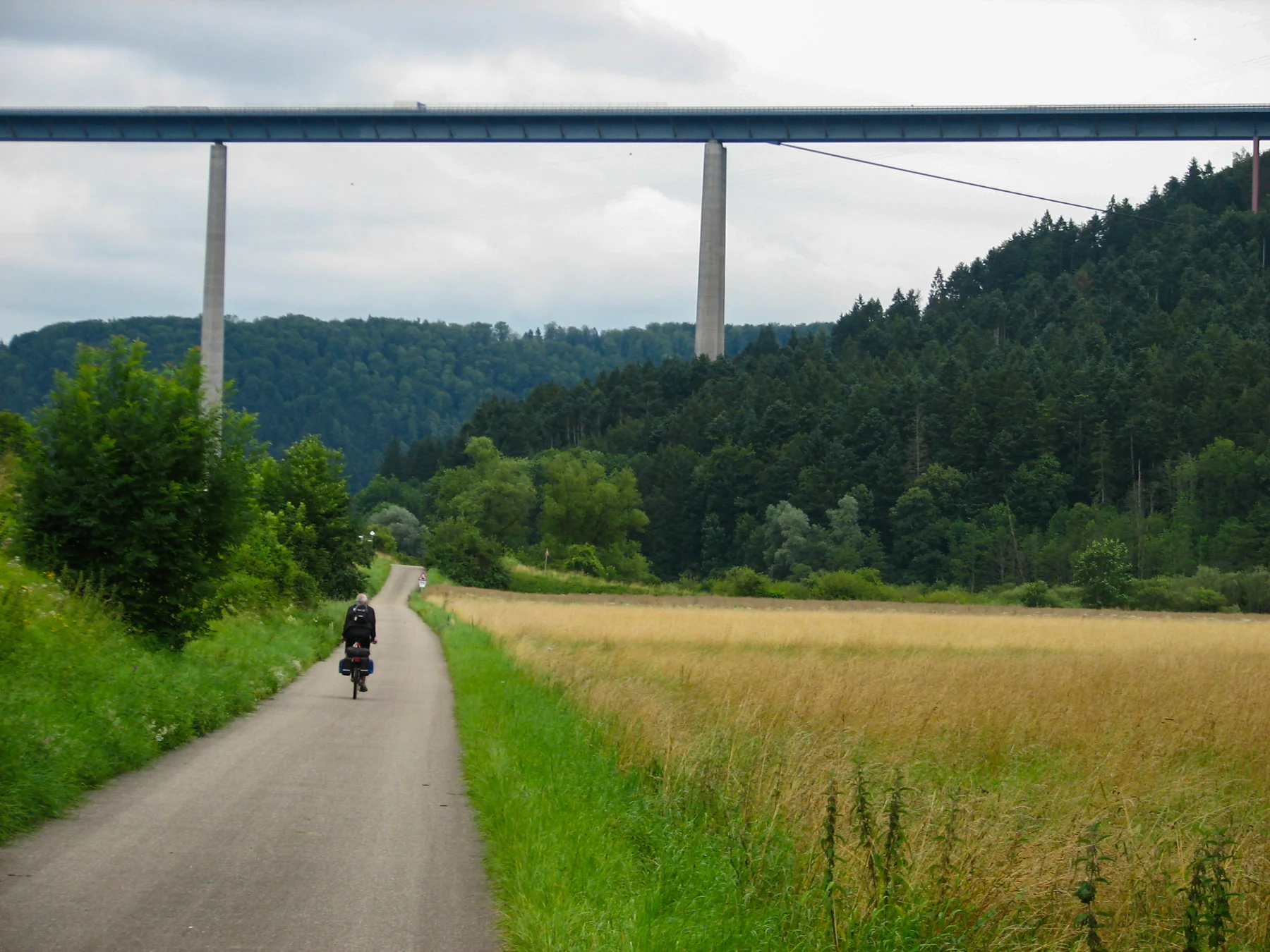Radfahrer auf dem Neckartal-Radweg unter der Neckartalbrücke Weitingen
